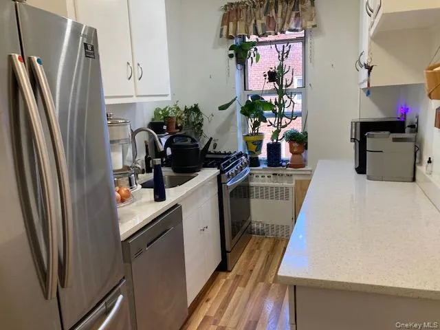 a kitchen with a refrigerator sink and cabinets