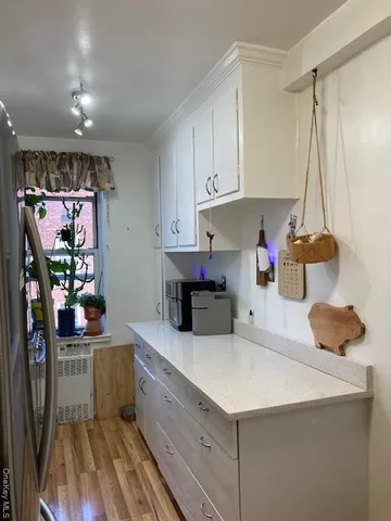 a bathroom with a sink a toilet a window and shower