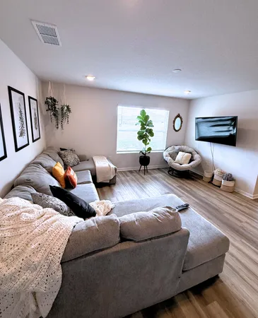 a view of a livingroom with wooden floor and furniture