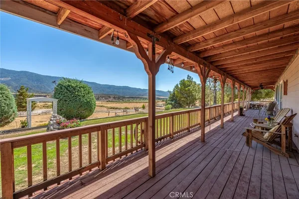 a view of a balcony with chairs and wooden floor