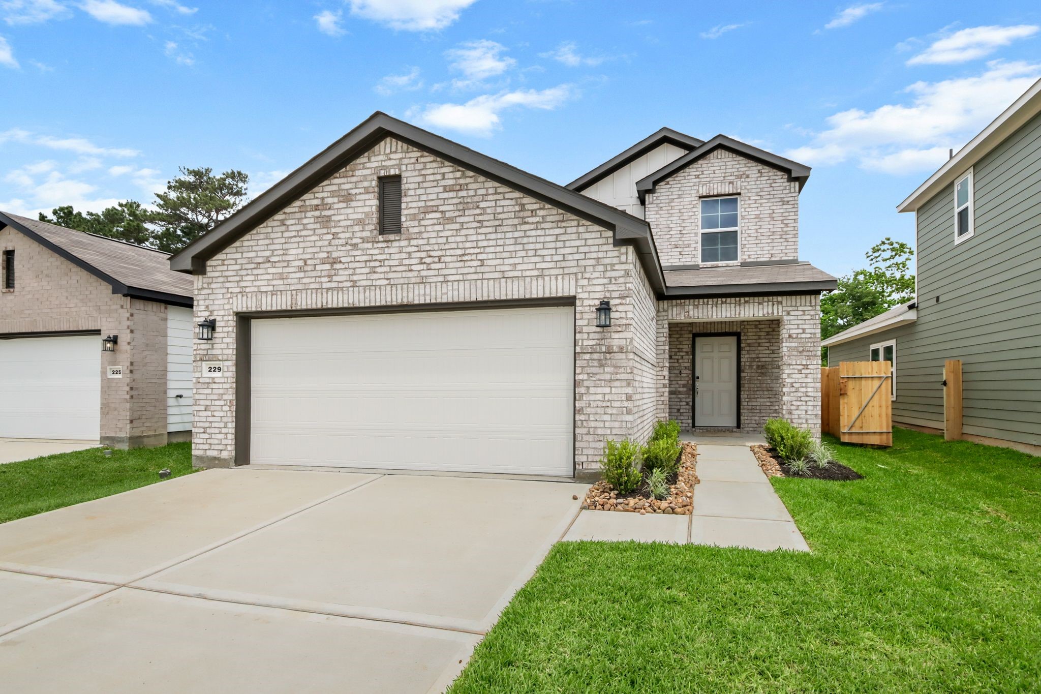 229 Spring Drive Hockley, TX 77447 - Photo 2 of 26 a front view of a house with a garden and plants
