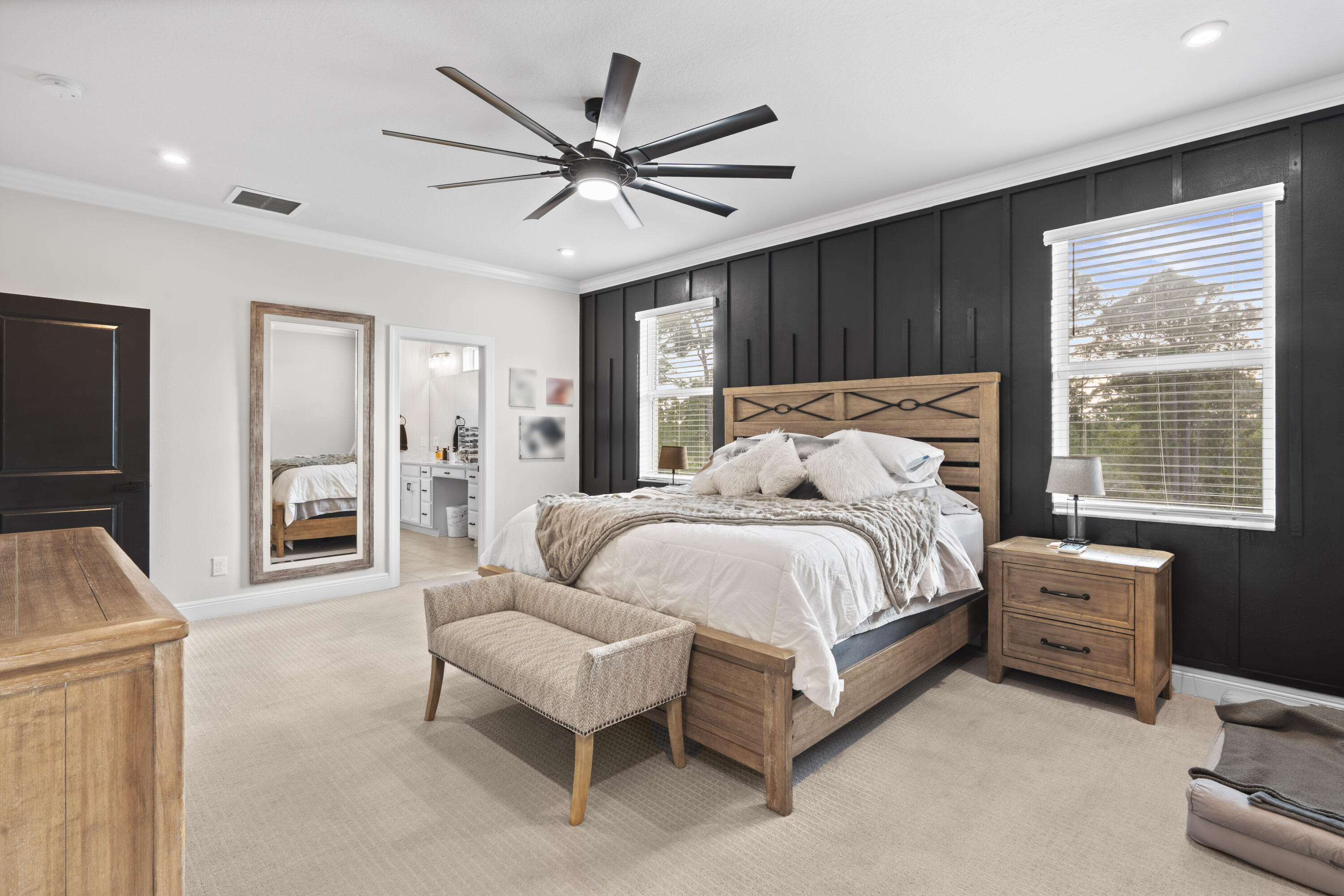 684 Southwest Pennfield Terrace Stuart, FL 34997 - Photo 24 of 61 a spacious bedroom with a bed a couch and a ceiling fan
