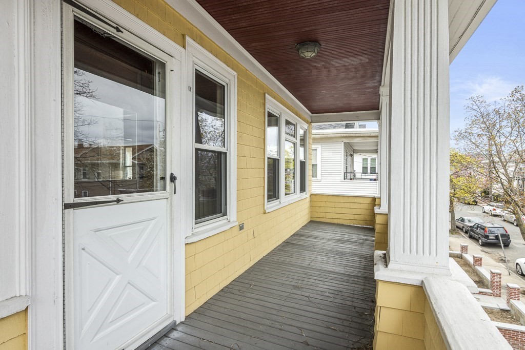 22 Wellington Road Medford, MA 02155 - Photo 14 of 16 a view of a hallway with wooden floor and furniture