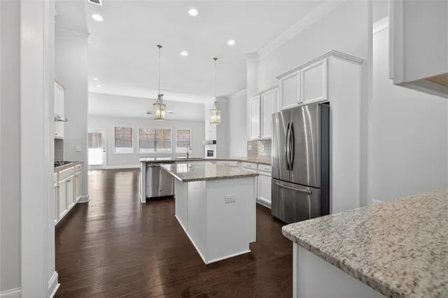 a kitchen with stainless steel appliances granite countertop a refrigerator and a sink