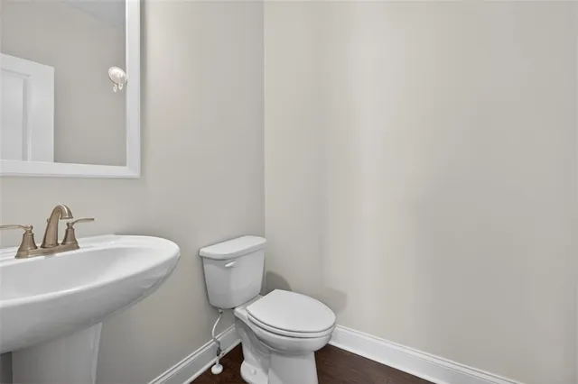 a bathroom with a toilet a sink and mirror