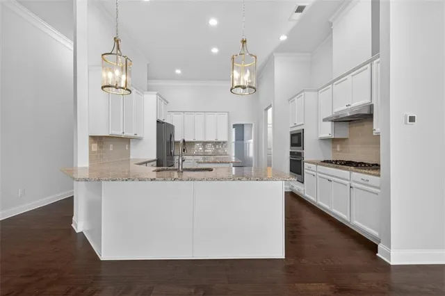 a kitchen with stainless steel appliances granite countertop a sink a stove and a refrigerator