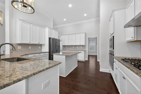 a kitchen with stainless steel appliances granite countertop a sink stove and refrigerator