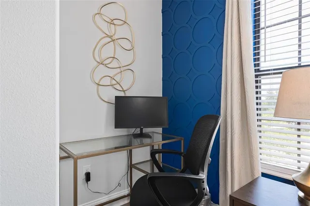 a view of workspace with wooden floor windows cabinet and chair