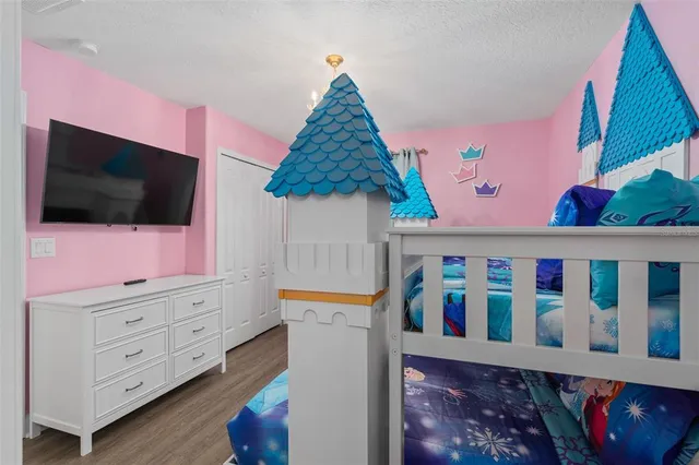 a bedroom with a bed and a flat tv screen on dresser