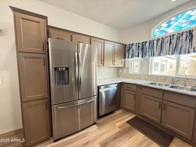 a kitchen with granite countertop a refrigerator and a sink