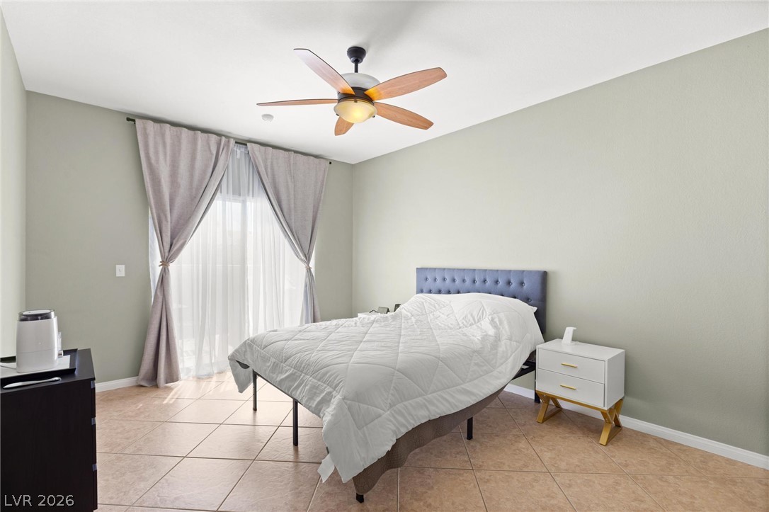 3238 Mystic Ridge Court Las Vegas, NV 89129 - Photo 8 of 31 Naturally illuminated bedroom features durable tile flooring and a ceiling fan for year-round comfort.