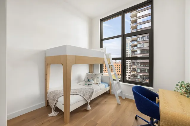 a spacious bedroom with a bed and a large window