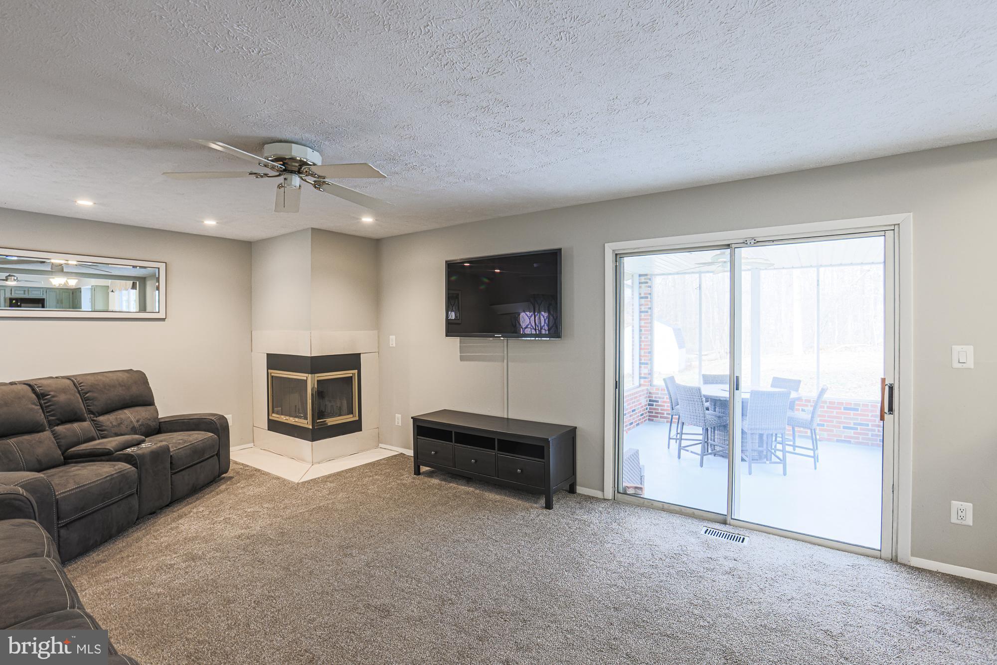 4402 Macworth Place Nottingham, MD 21236 - Photo 14 of 36 a living room with furniture a flat screen tv and a fireplace