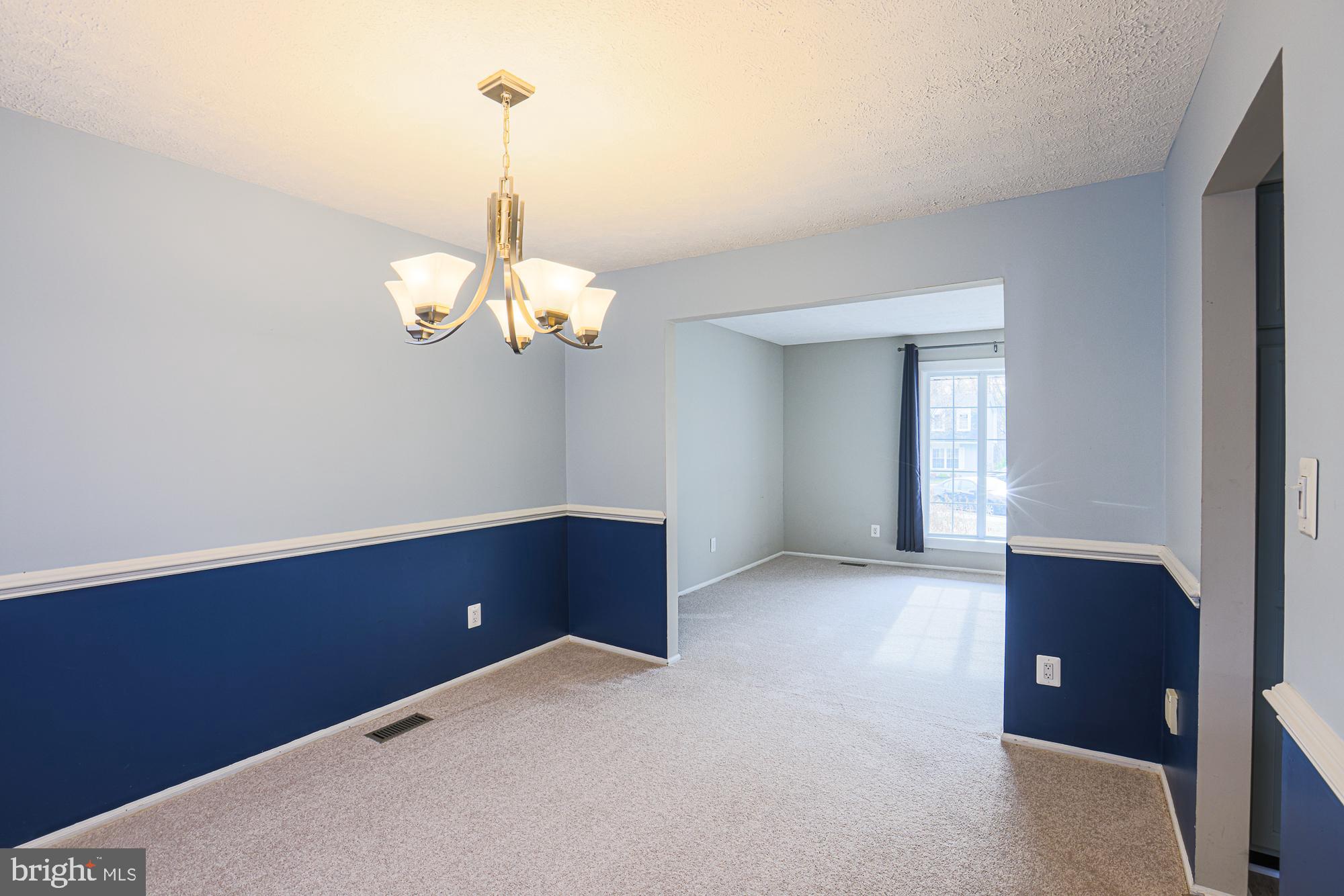 4402 Macworth Place Nottingham, MD 21236 - Photo 8 of 36 a view of an empty room with a chandelier fan and a table