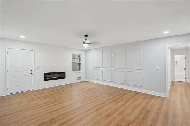 a view of empty room with wooden floor and window