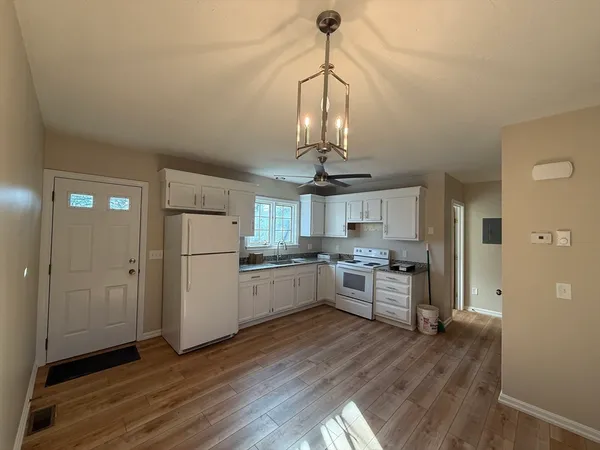 a kitchen with stainless steel appliances granite countertop a refrigerator a stove a microwave and a wooden floors