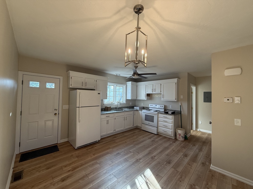 230 Beacon Street, Unit 3 Clinton, MA 01510 - Photo 4 of 13 a kitchen with stainless steel appliances granite countertop a refrigerator a stove a microwave and a wooden floors