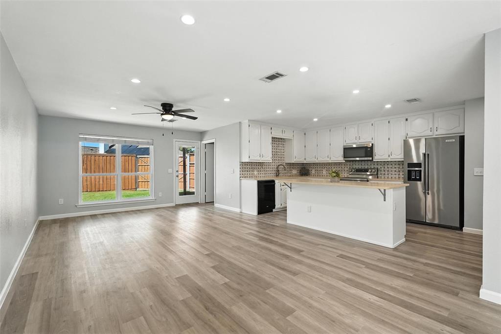 1402 Country Lane Allen, TX 75002 - Photo 37 of 39 Kitchen with open floor plan, a center island, appliances with stainless steel finishes, decorative backsplash, and recessed lighting