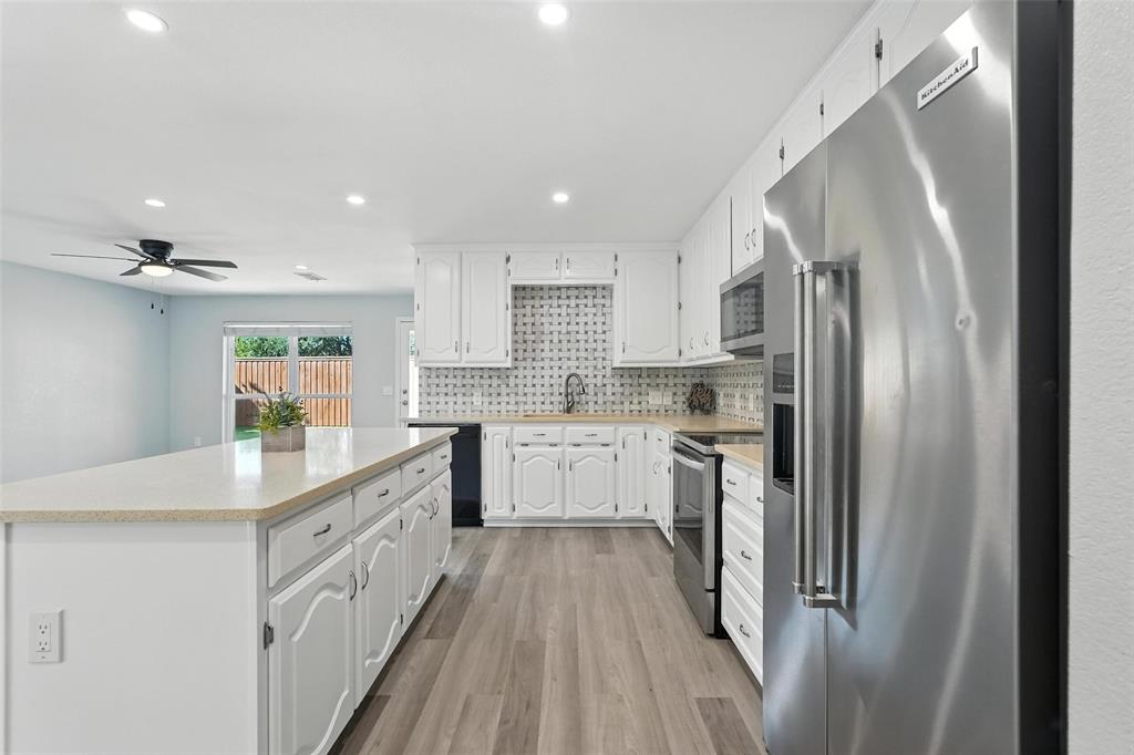 1402 Country Lane Allen, TX 75002 - Photo 13 of 39 Kitchen featuring stainless steel appliances, white cabinetry, decorative backsplash, a center island, and recessed lighting