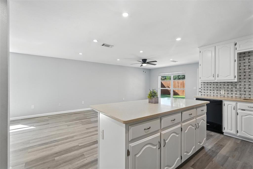 1402 Country Lane Allen, TX 75002 - Photo 38 of 39 Kitchen featuring white cabinetry, tasteful backsplash, open floor plan, a kitchen island, and recessed lighting