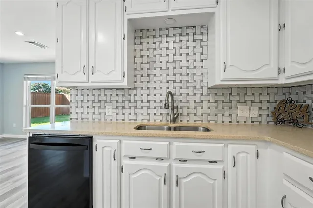 a kitchen with white cabinets and appliances