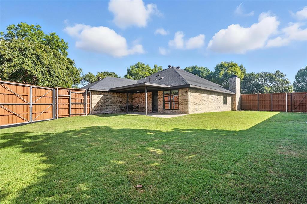 1402 Country Lane Allen, TX 75002 - Photo 34 of 39 Back of house with a gate, a patio area, a fenced backyard, a chimney, and brick siding