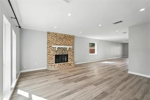 a view of an empty room with a fireplace and a window