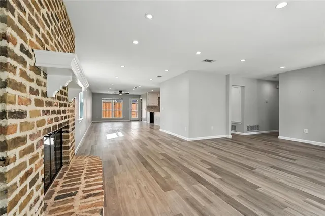 a view of a room with wooden floor and windows