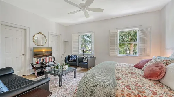 a bedroom with a bed a table and a book shelf