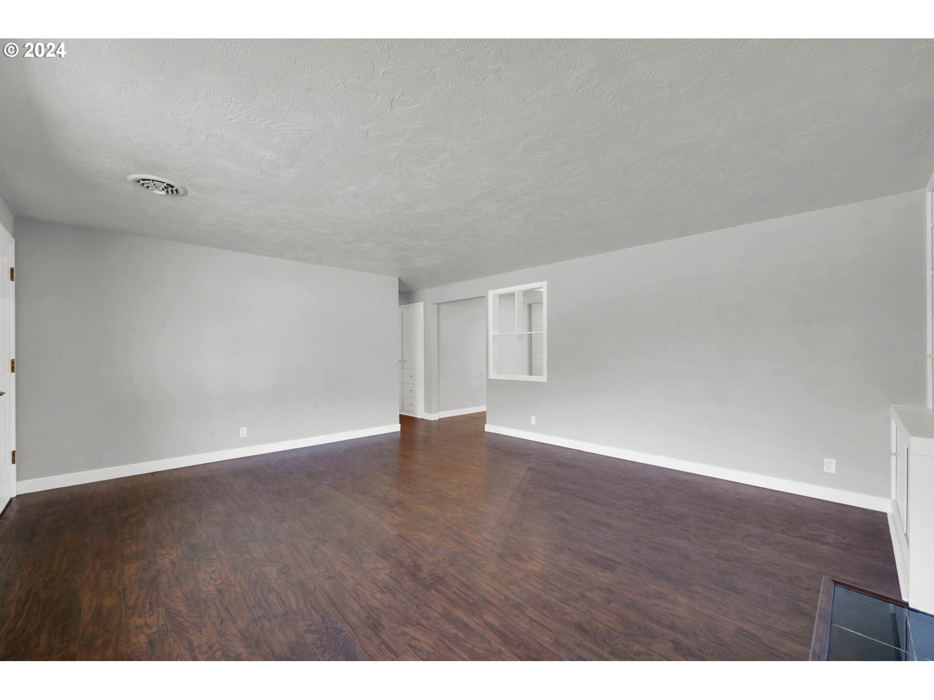2466 Corral Court Springfield, OR 97477 - Photo 5 of 28 a view of an empty room with wooden floor and a window