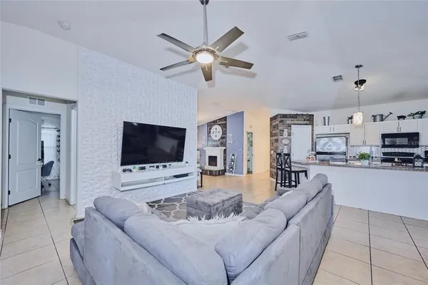 a kitchen with stainless steel appliances granite countertop a refrigerator a sink a stove and white cabinets