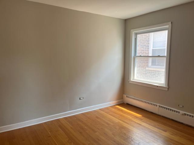 6100 South Kenneth Avenue, Unit 2 Chicago, IL 60629 - Photo 12 of 14 a view of an empty room with wooden floor and a window