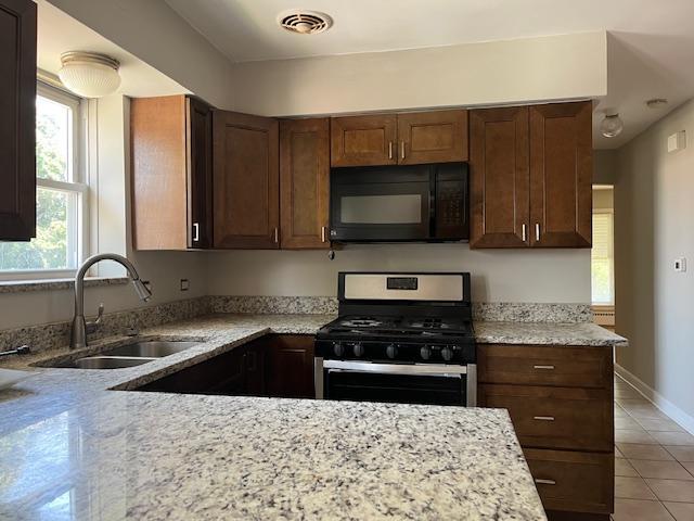 6100 South Kenneth Avenue, Unit 2 Chicago, IL 60629 - Photo 9 of 14 a kitchen with granite countertop a sink and a stove top oven with wooden floor