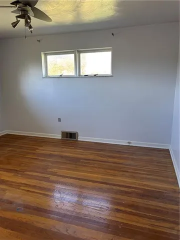a view of a room with wooden floor and windows