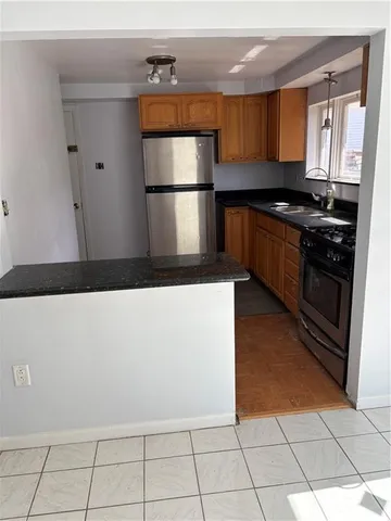a kitchen with granite countertop a refrigerator and a stove top oven