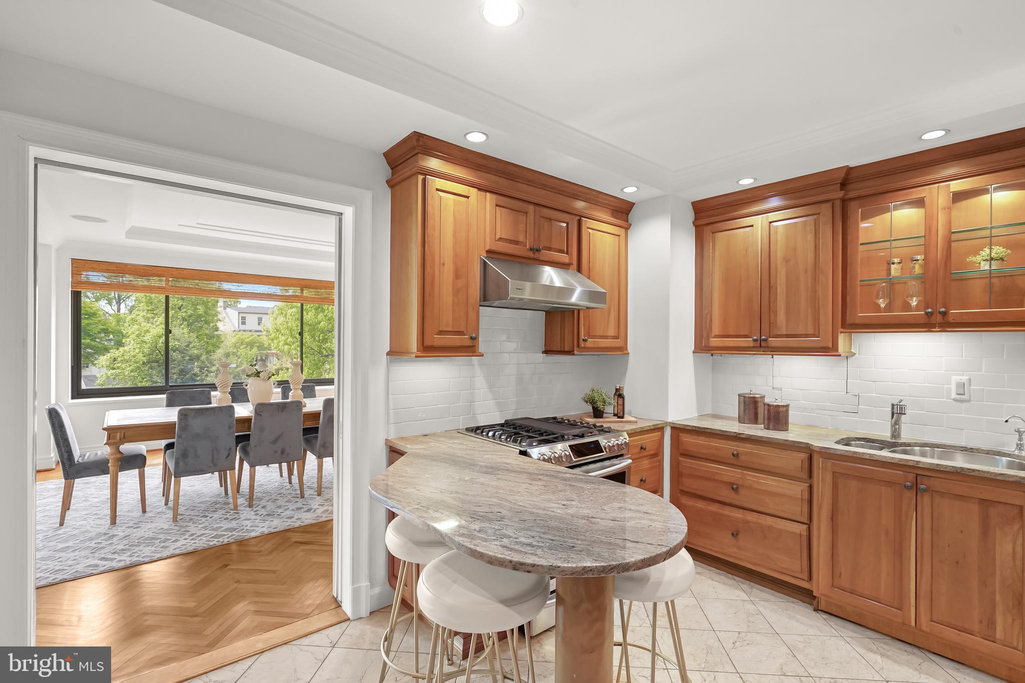 2700 Calvert Street Northwest, Unit 416 Washington, DC 20008 - Photo 10 of 33 a kitchen with a stove a sink a dining table and chairs