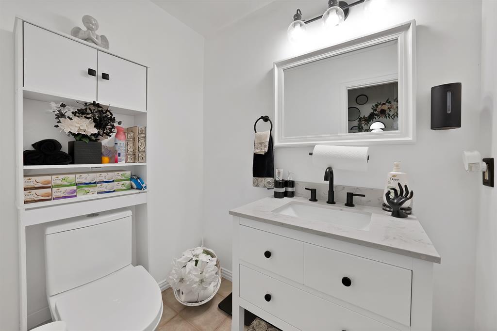 2716 Rochelle Point Irving, TX 75062 - Photo 25 of 40 White vanity with an integrated sink, matte black faucet, and a light-colored countertop