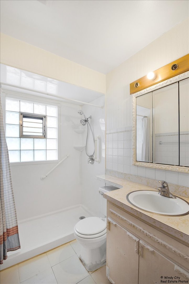 383 Raupp Boulevard Buffalo Grove, IL 60089 - Photo 17 of 40 a bathroom with a sink a toilet and shower