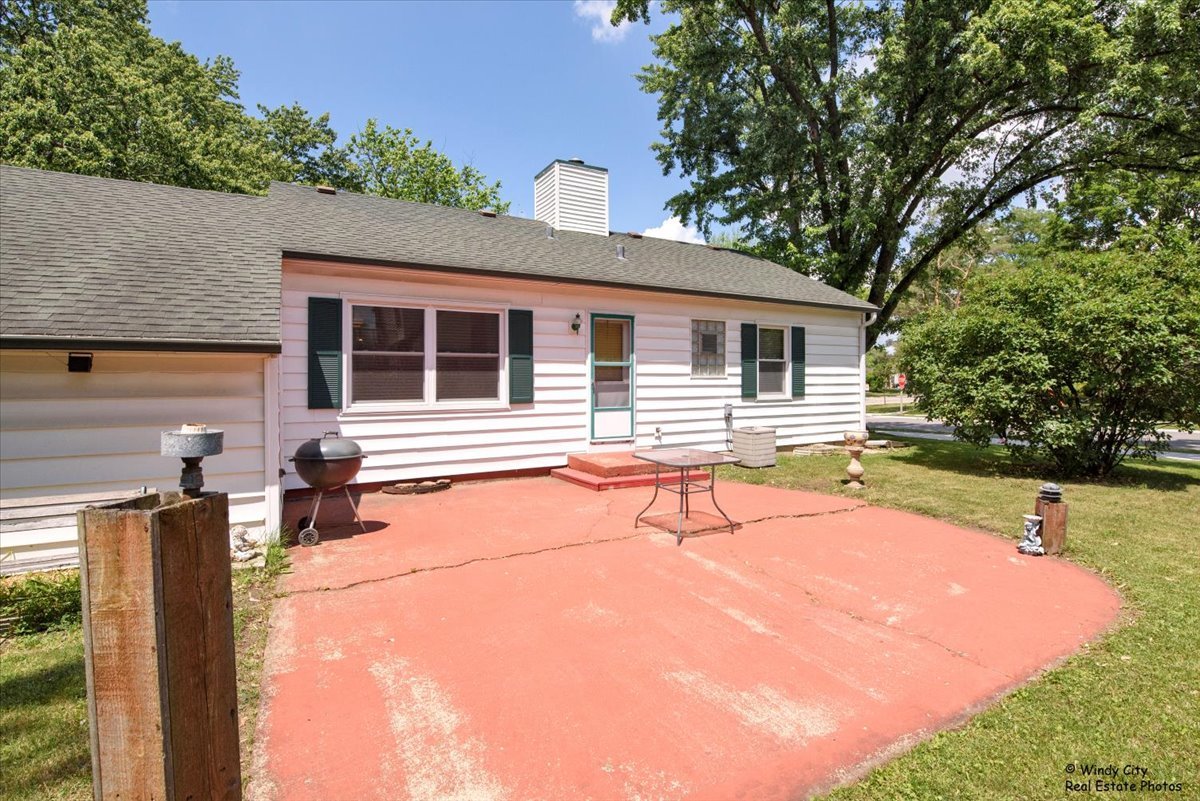 383 Raupp Boulevard Buffalo Grove, IL 60089 - Photo 30 of 40 a backyard of a house with table and chairs and wooden fence