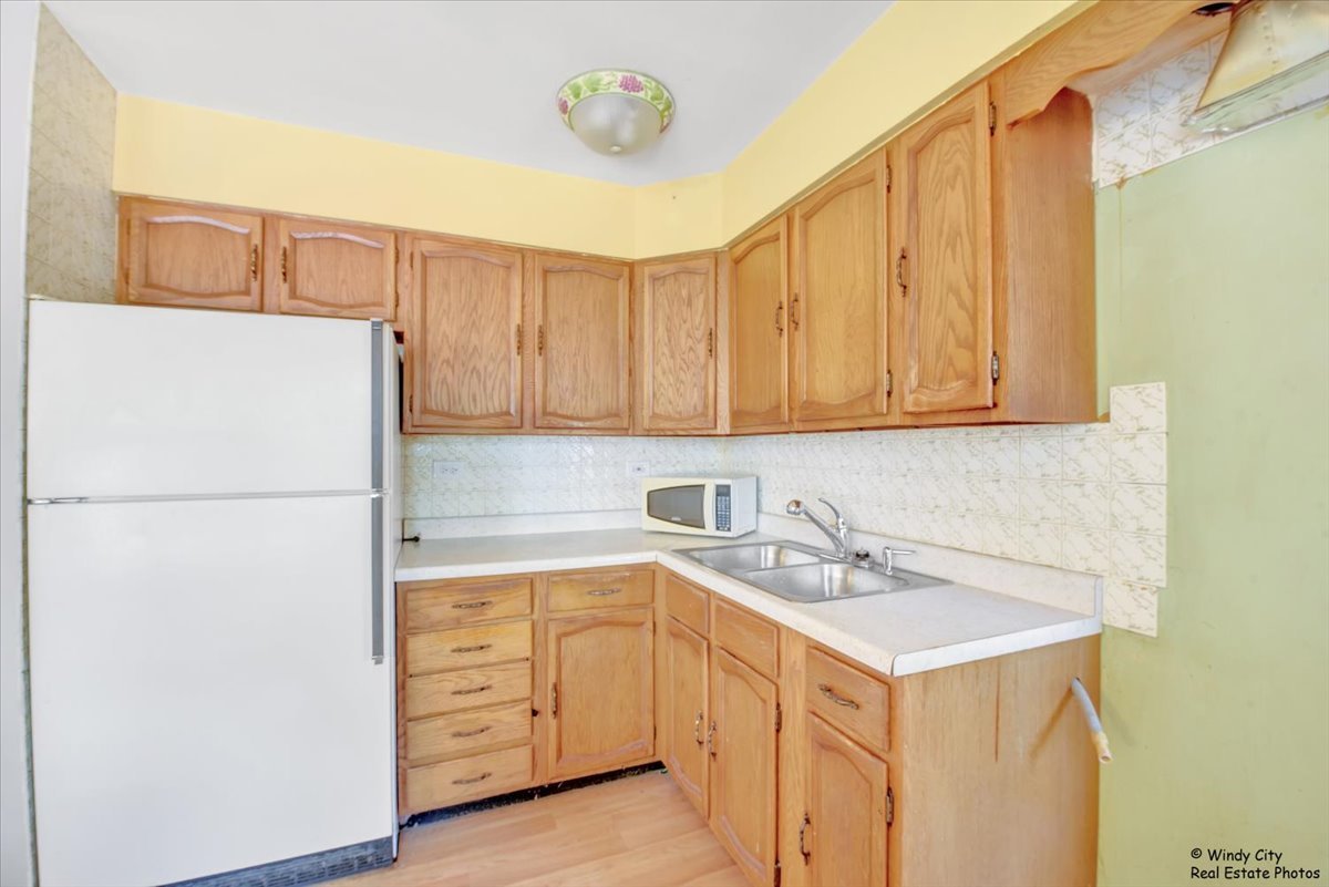 383 Raupp Boulevard Buffalo Grove, IL 60089 - Photo 6 of 40 a kitchen with a sink a refrigerator and cabinets