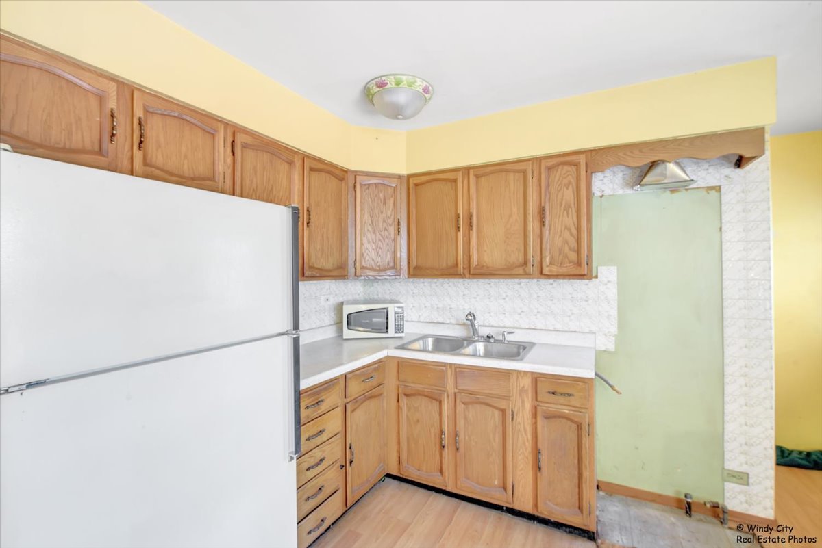 383 Raupp Boulevard Buffalo Grove, IL 60089 - Photo 7 of 40 a kitchen with a sink a refrigerator and cabinets