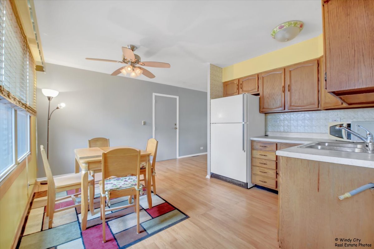 383 Raupp Boulevard Buffalo Grove, IL 60089 - Photo 9 of 40 a living room with a dining table chairs and refrigerator