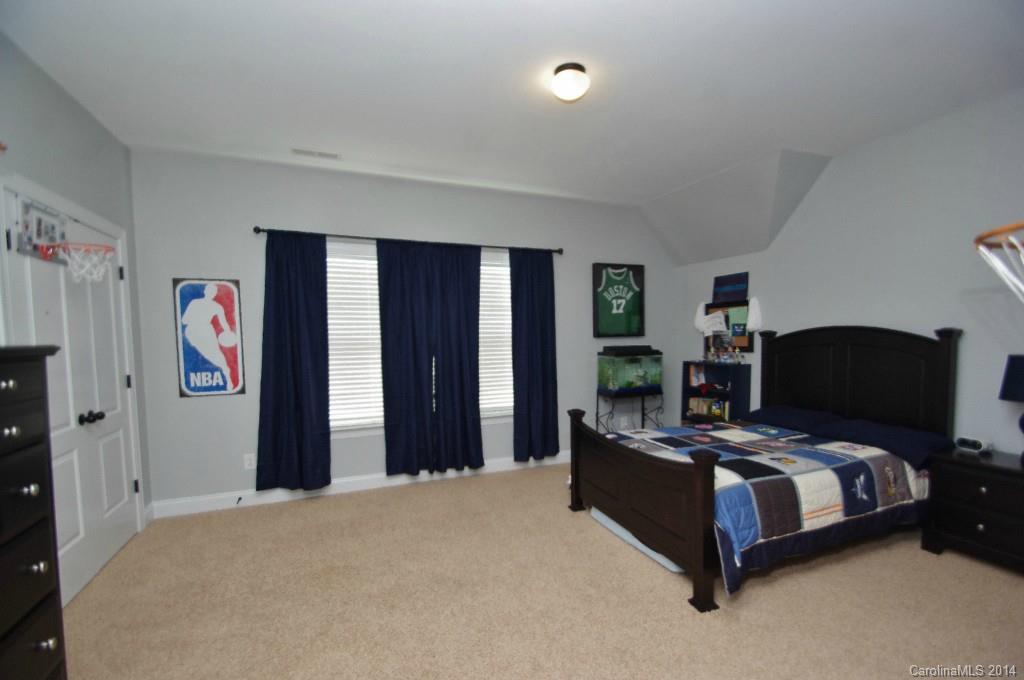 1010 Hamil Ridge Drive, Unit 929 Waxhaw, NC 28173 - Photo 17 of 24 a bedroom with a bed painting on wall and a window