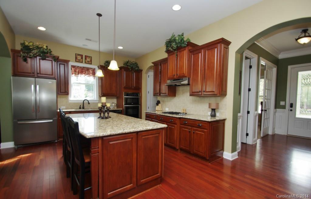 1010 Hamil Ridge Drive, Unit 929 Waxhaw, NC 28173 - Photo 10 of 24 a kitchen with stainless steel appliances granite countertop a refrigerator a sink dishwasher a stove and a wooden floor
