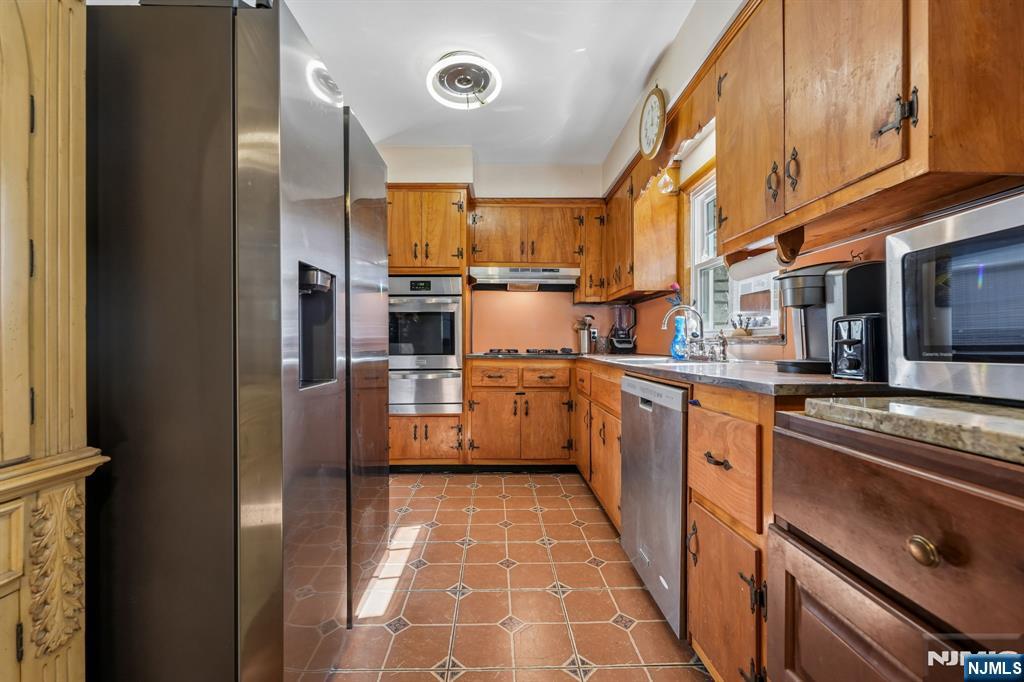 140 Francisco Avenue Rutherford, NJ 07070 - Photo 10 of 25 a kitchen with stainless steel appliances granite countertop a refrigerator a stove and a sink with wooden floor