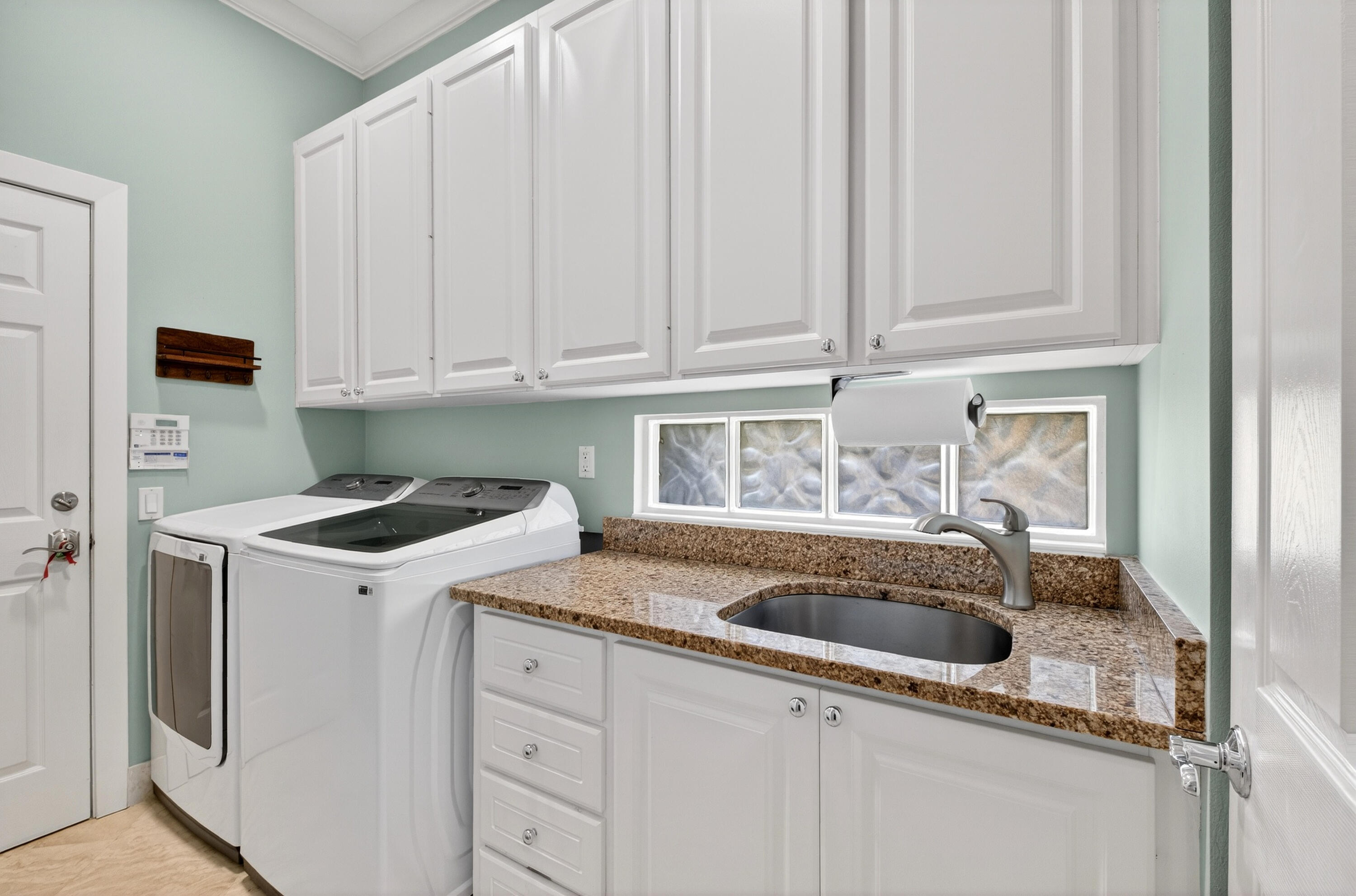 8223 Pine Cay Road Wellington, FL 33414 - Photo 29 of 60 a kitchen with granite countertop white cabinets and sink