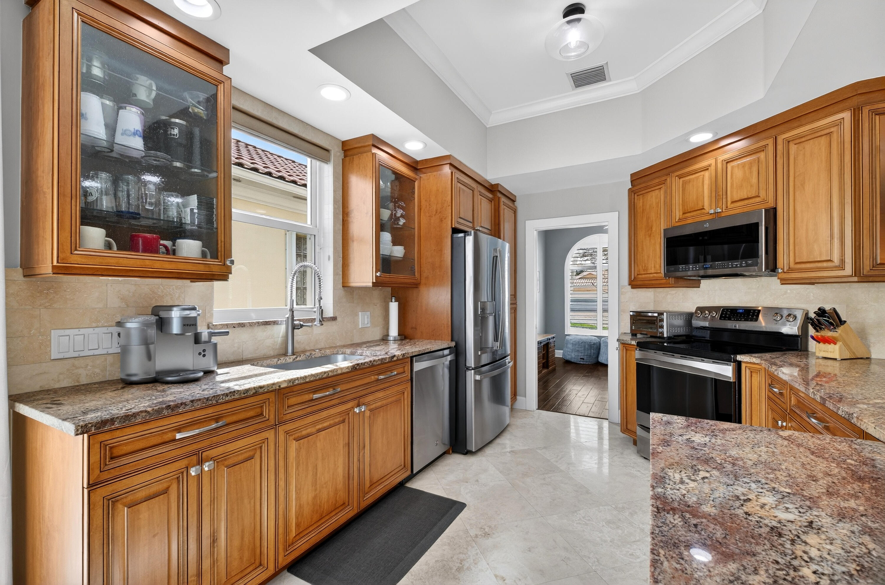 8223 Pine Cay Road Wellington, FL 33414 - Photo 3 of 60 a kitchen with stainless steel appliances granite countertop a stove refrigerator sink and microwave