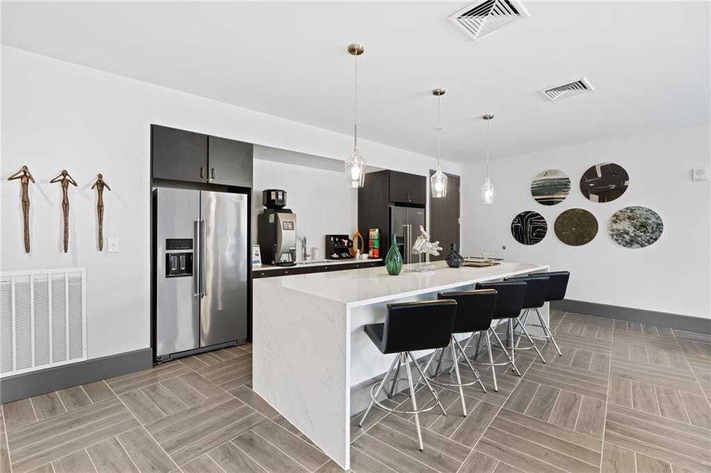 775 Juniper Street Northeast, Unit 227 Atlanta, GA 30308 - Photo 27 of 42 a kitchen with a sink a refrigerator and chairs