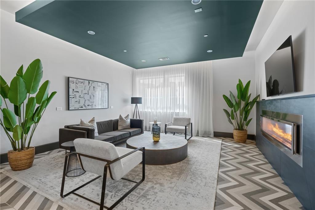 775 Juniper Street Northeast, Unit 227 Atlanta, GA 30308 - Photo 32 of 42 a living room with furniture a potted plant and a fireplace