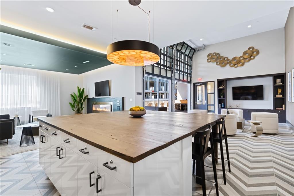 775 Juniper Street Northeast, Unit 227 Atlanta, GA 30308 - Photo 33 of 42 a kitchen with a table chairs and flat screen tv